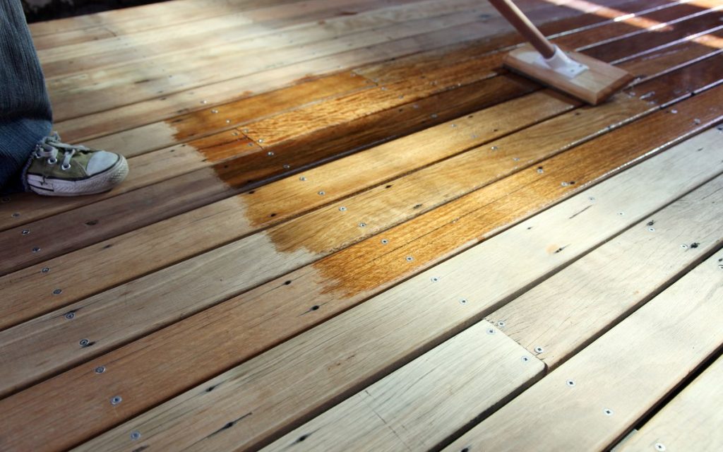 Oiling a recycled timber outdoors deck for protection against the elements