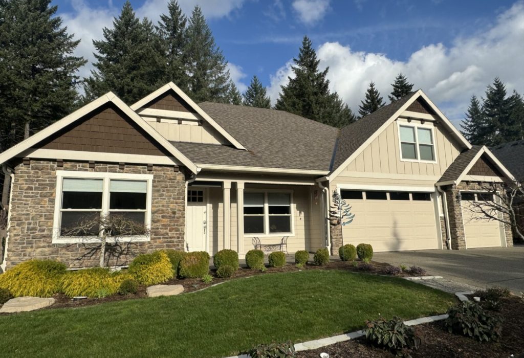 Single-story suburban house with a stone facade and an attached garage on a sunny day.